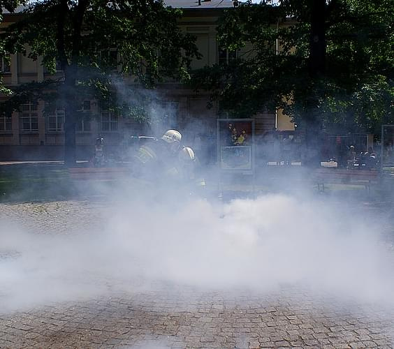 Pokaz gaszenia stosu drewienek przy pomocy gaśnic, podczas otwarcia strażackiej wystawy w kaliskim muzeum