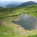 Widok na otoczenie jeziorka z przełęczy w grani głównej, w tle Homuł.