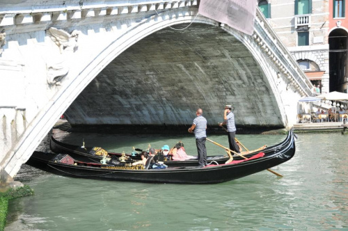 Wenecja - przepływająca gondola pod mostem Rialto.