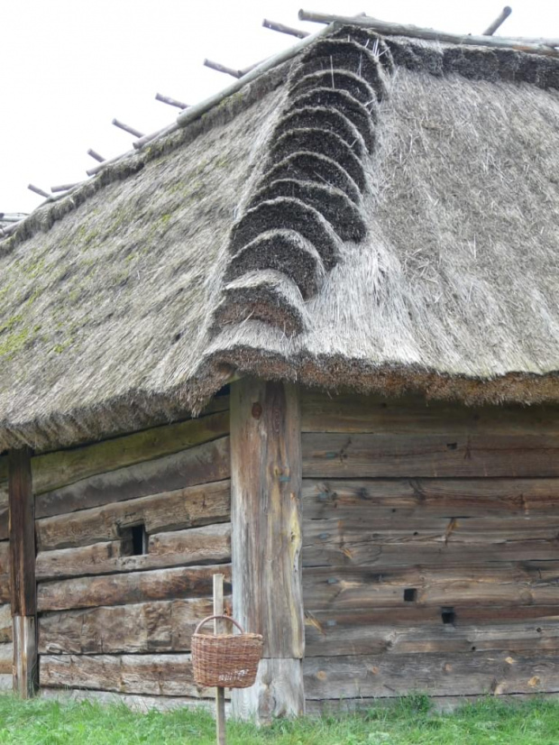 Coś w zbliżeniu. Piękna strzecha, a przed cosiem śmietnik z wikliny