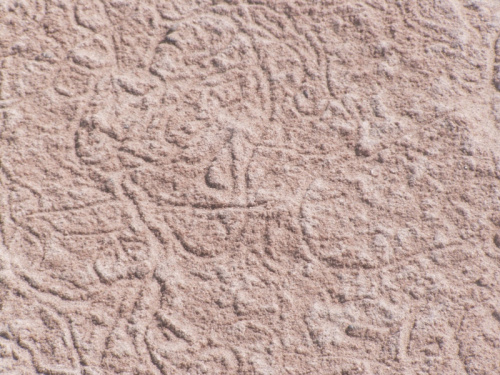 Znaki na piasku - namalowały je tycie krabiki podążające z muszelkami za morzem