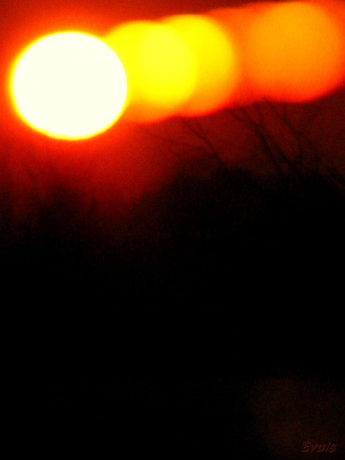9.01.2009 był straszny mróz, nie chciałam zmarznąć i dlatego fotografowałam zachód słońca przez szybę(okno) i tak wyszło. Spodobało mi się.