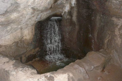 Łagodny stok prowadzi ku wejściu do głębokiej jaskini, ze sklepieniem opartym na wielkim bloku granitu, skąd wytryska obfite i burzliwe źródełko. Jaskinia ta poświęcona jest Szczęściu #UKRAINA