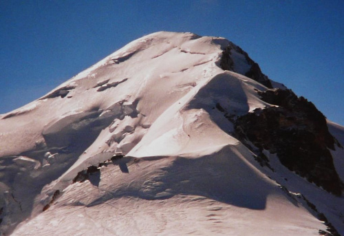 18.08.2001 ok. 9:50.
Z drogi zejściowej. Na dole Col du Dome (4237 m). Powyżej widzć dwa schrony, Obserwatorium Meteorologiczne z lewej i schron Vallot z prawej.Nad schronami grań Bosses. #Alpy #Francja